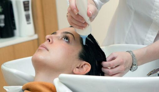 Maestrul aplică produsul pe măsură ce trece prin păr